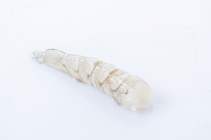 殻をむき、背わたを取り除いた尾を切った生の冷凍エビ